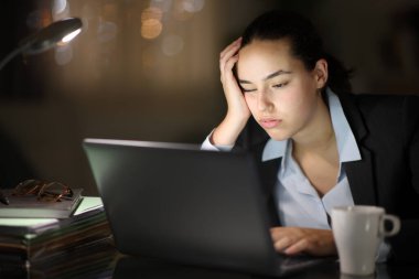 Gece yarısı dizüstü bilgisayarla çalışmaktan yorgun düşmüş.
