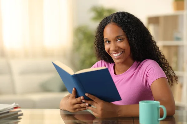 Happy Black Reader Looking Camera Holding Paper Book Home Stock Picture
