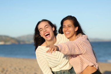 Mutlu arkadaşlar uzaklaşıyor ve sahilde yüksek sesle gülüyorlar.