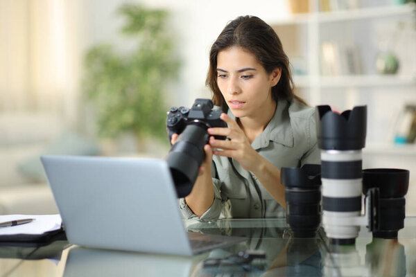 Заинтересованный фотограф проверяет зеркальную камеру дома