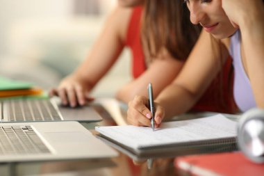 İnternette öğrenen ve bir masaya not alan iki öğrenciye yakın çekim