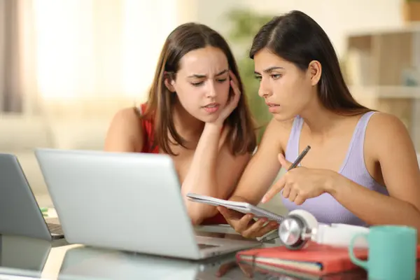 Two worried students studying online at home