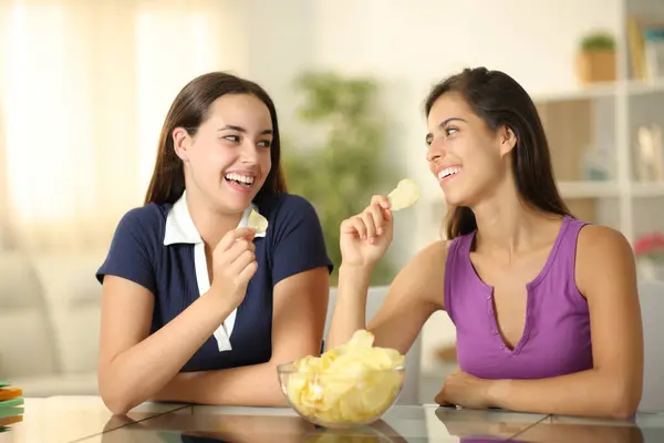 Двоє Щасливих Друзів Розмовляють Їдять Картопляні Чіпси Вдома — стокове фото