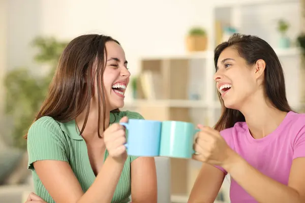 Дві Щасливі Друзі Тости Чашками Кави Сміються Вдома — стокове фото