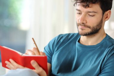 Ciddi bir adam kırmızı gündemde evde oturuyor.