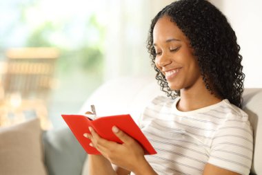 Evdeki kırmızı kağıt gündemine yazan mutlu siyah kadın.