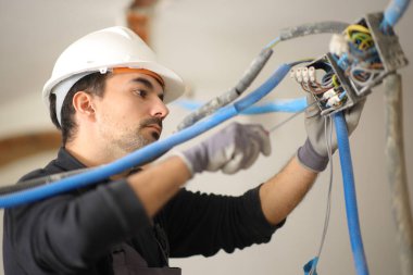Reform altındaki bir eve elektrik sistemi kuran elektrikçi