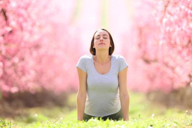 Pembe bir tarlada yoga yapan bir kadının portresi.