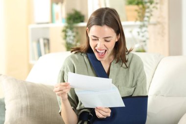 Evinde iyi haberi kutlayan heyecanlı iyileşme sürecindeki kadın kitap okuyor.