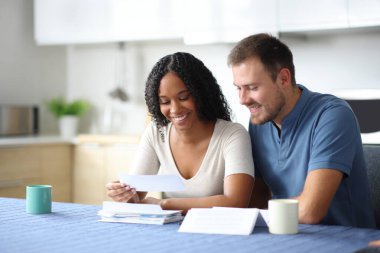 Mutlu çift ya da ev arkadaşları mutfaktaki makbuzu kontrol ediyor.