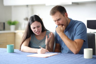 Kızgın çift evdeki mutfakta kötü kağıt kontratlarını kontrol ediyor.