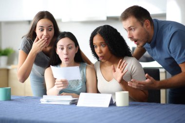 Şaşırmış ırklar arası arkadaşlar evdeki mutfakta makbuzu kontrol ediyor.