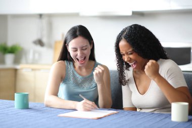 Heyecanlı ırklar arası çiftler, evde mutfaktaki başarılarını kutlamak için kontrat imzalıyorlar.