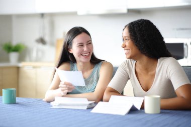 Mutlu ırklar arası oda arkadaşları mutfaktaki banka hesaplarını kontrol ediyor.