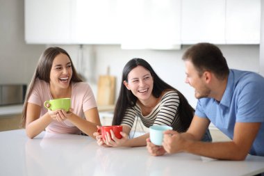 Evdeki mutfakta gülen ve içen üç komik arkadaş.