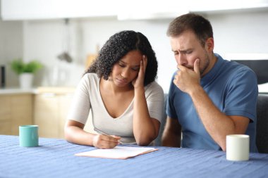 Endişeli bir çift ya da ev arkadaşı evdeki mutfakta kontrat yapıyor.