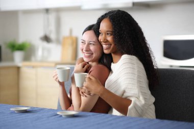 Mutlu, ırklar arası bir çift. Sarılmak, içmek ve evdeki mutfakta kafa yormak.