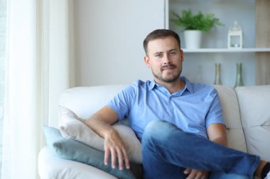 Evdeki kanepede oturup sana bakan rahat bir adamın portresi.