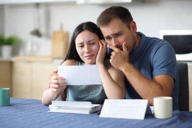 Evdeki mutfakta ırklar arası kitap tasarısı okuyan endişeli bir çift.