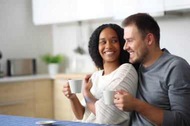 Birbirlerine aşık mutlu çiftler kahve saatinde evde birbirlerine bakarlar.