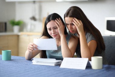 Üzgün ev arkadaşları banka hesaplarını kontrol ediyor ve mutfaktaki bir mutfaktan şikayet ediyorlar.