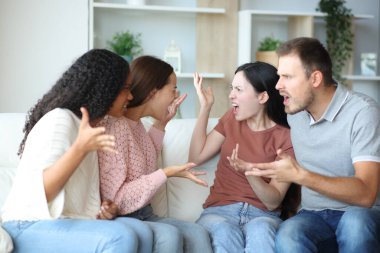 Dört oda arkadaşı evdeki kanepede oturup tartışıyor.