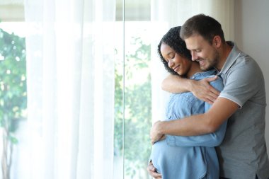 Mutlu, ırklar arası bir çift hamileliğin tadını çıkarıyor ve evde karnına bakıyor.