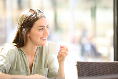 Mutlu kadın kahve içiyor güneşli bir günde bir restoranda tefekkür ediyor.