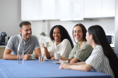 Irklar arası arkadaşlar evdeki mutfakta içki içip sohbet ediyorlar.