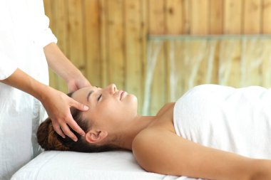 Spa 'da yüz masajı yaptıran rahat bir kadının profili.