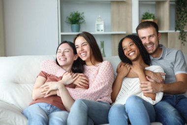 İki mutlu çift evdeki kanepede oturmaktan zevk alıyor.