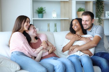 İki ırklar arası çift evdeki koltukta oturup konuşuyor.