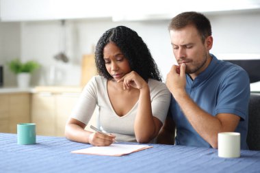 Şüpheli ırklar arası oda arkadaşları bir ev mutfağında kontrat okuyorlar.