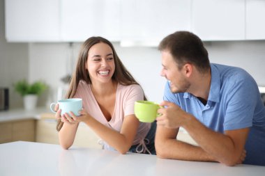 Evdeki mutfakta içki içip sohbet eden komik bir çift.