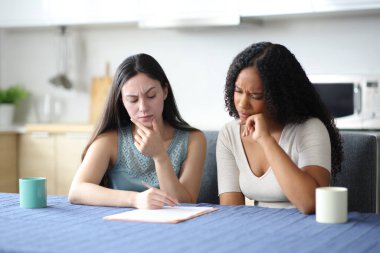 Şüpheli ırklar arası oda arkadaşları evdeki mutfakta kontrat okuyorlar.