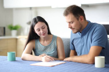 Irklar arası oda arkadaşları evdeki mutfakta kağıt sözleşmesi imzalıyorlar.