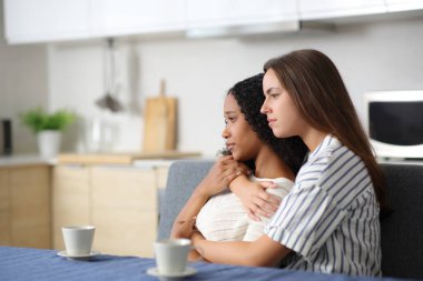 Ciddi bir ırklar arası çift evdeki mutfaktan uzağa bakıyor.