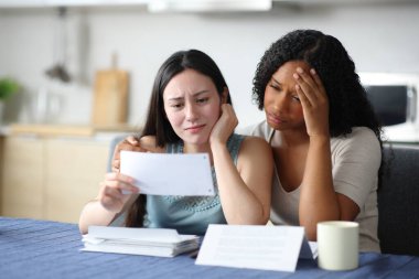 Farklı lezbiyen çiftler mutfaktaki hesap özetlerini kontrol ediyor.