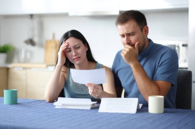 Evdeki mutfakta kötü haberler okuyan kederli ırklar arası bir çift.