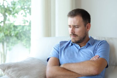 Üzgün adam tek başına şikayet ediyor. Evdeki bir kanepede oturuyor.