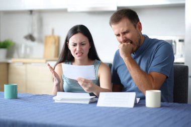 Kızgın, ırklar arası bir çift mutfaktaki banka hesaplarını kontrol ediyor.