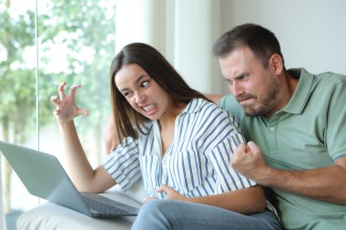 Kızgın çift evdeki kanepede oturup bilgisayardaki içeriği kontrol etmekten şikayetçi.