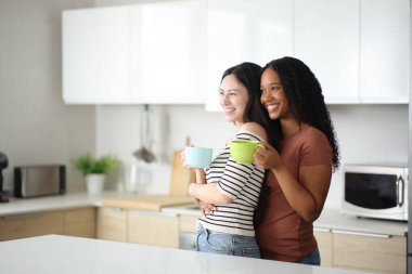 Mutfaktaki mutfakta kahvaltıda mutfaktaki lezbiyenlerin ırklar arası çifti.