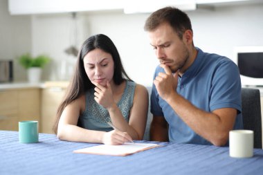 Şüpheli bir ırklar arası çift ya da ev arkadaşları evdeki mutfakta belgeleri kontrol ediyorlar.