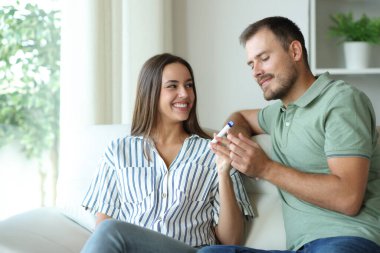 Bir çift ya da arkadaşlar evdeki bir kanepede oturup Vaper içiyorlar.