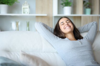 Mutlu kadın evinde rahat bir koltukta dinleniyor.