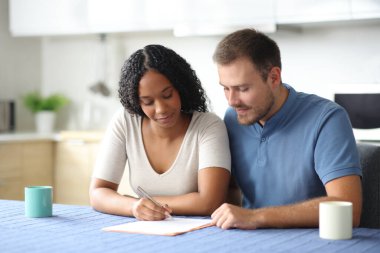 Evdeki mutfakta ırklar arası kontrat imzalayan bir çift.