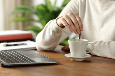 Evdeki masada kahve karıştıran bir öğrencinin portresini kapat.