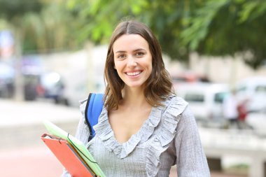Öğrenci poz veriyor, gülümsüyor ve kameraya bakıyor.
