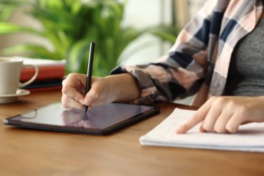 Tablete yazı yazan öğrenci ellerini kapat. Evdeki not defterini kontrol et.